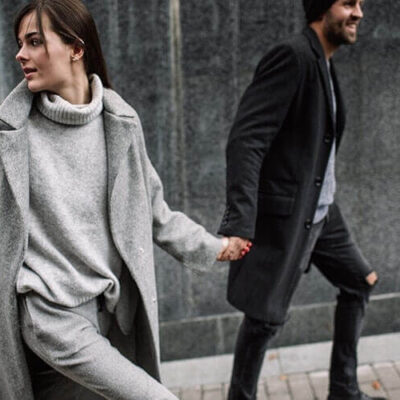 man and woman walking hand in hand, woman looking back